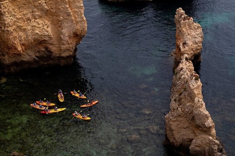 Kayaker, kayaks, kayaking, guided tour through grottos, rocks in the sea, Ponta da Piedade, Lagos,
