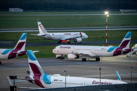 Düsseldorf Airport, Eurowings aircraft, in parking position, Tunisair on the taxiway for take-off