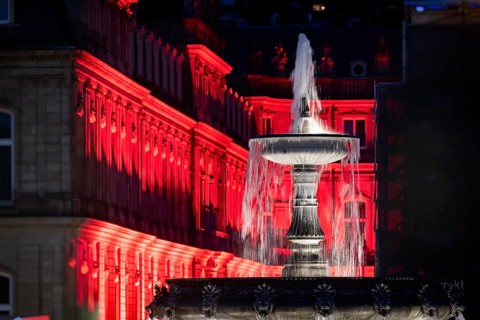 Court of honour on Schlossplatz. The New Palace and fountain are illuminated. Stuttgart,