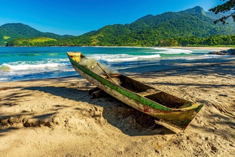 Primitive wooden fishing canoe on the sands of Castelhanos beach in Ilhabela, Castelhanos beach,