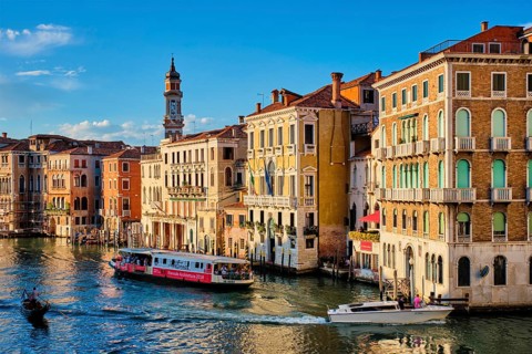 VENICE, ITALY, JUNE 27, 2018: Grand Canal with boats, vaporetto and gondolas on sunset from Rialto