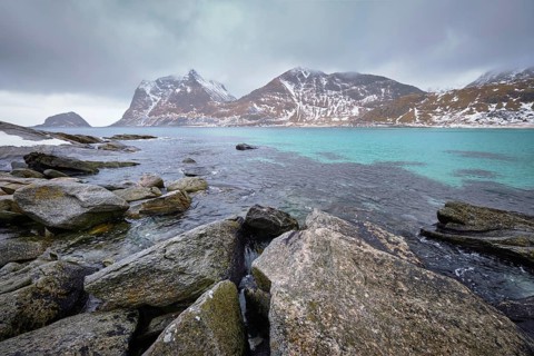 Rocky coast of fjord of Norwegian sea in winter with snow. Haukland beach, Lofoten islands, Norway,