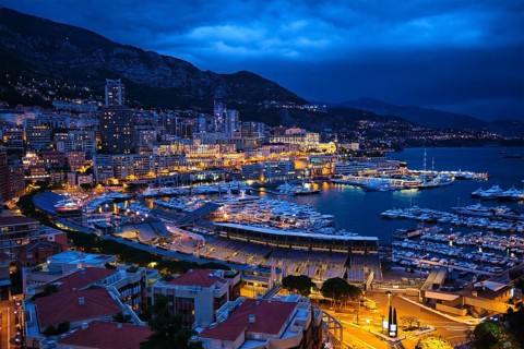 Aerial view of Monaco Monte Carlo harbour and illuminated city skyline in the evening blue hour