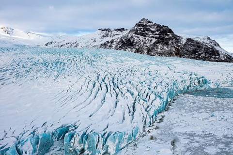 Snow-covered icebergs in the Fjallsarlon glacier lagoon, with the Öraefajökull glacier behind,