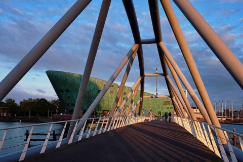 AMSTERDAM, NETHERLANDS, MAY 9, 2017: NEMO Science museum and Mr. J. van der Veldebrug bridge. It is