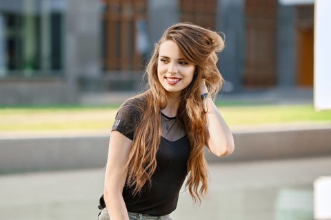 Positive and happy young woman with long curly hair outdoor