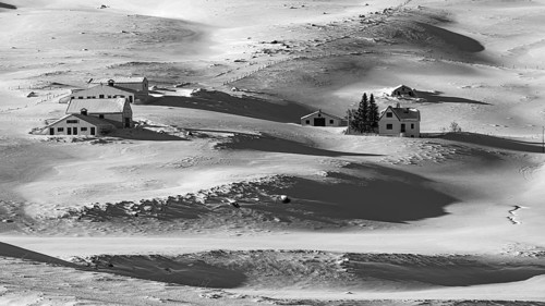 Farmhouse in snow-covered hilly landscape, near Akureyri, black and white photo, Northern Iceland