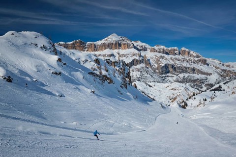 View of a ski resort piste with people skiing in Dolomites in Italy. Ski area Arabba. Arabba,