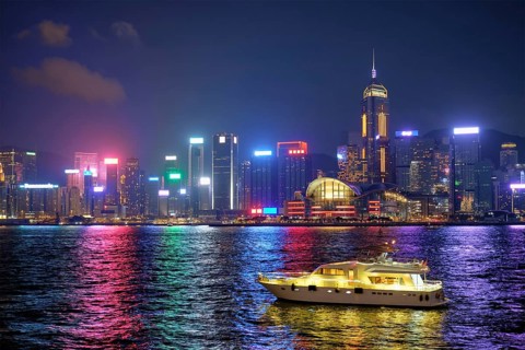 Hong Kong skyline cityscape downtown skyscrapers over Victoria Harbour in the evening illuminated