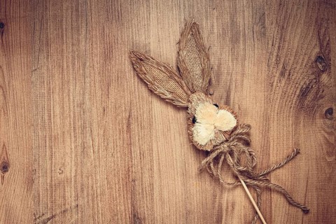 Easter bunny made of straw, on a wooden background, top view, no people