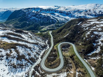 Aerial view of mountain road over the Haukelifjell, winding down to Roeldal, early spring, Norway,