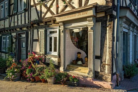 Idyllic old half-timbered house with floral decorations and shop window of milliner, milliner, hat