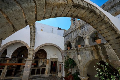 Historic courtyard with stone arches and white walls in a Mediterranean atmosphere, Agiou Theologou