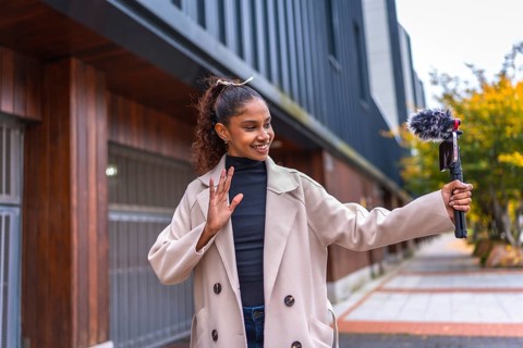 Afro beauty woman streaming online waving at camera outdoors in the city