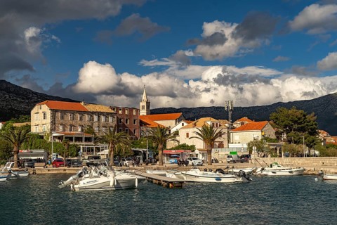 Town view with harbour and church Crkva Marija Pomocnica in Orebic, Peljesac peninsula, Croatia,