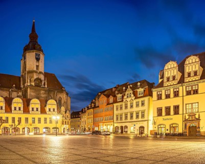 The market square with the Wenceslas Church and town houses with Renaissance gables at dusk,