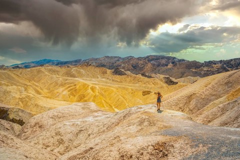 A young woman in dress enjoying the view of the viewpoint of Zabriskie Point, California. United
