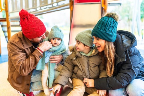 Cheerful parents are enjoying wintertime with their children at an indoor playground, creating a