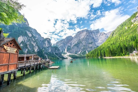 Tourists kayaking on the serene emerald waters of lake braies, surrounded by the breathtaking