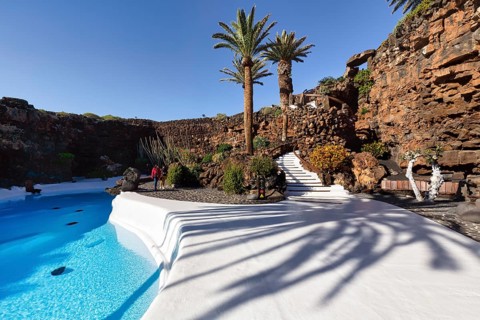 Palm trees, people walking by the swimming pool, Jameos del Agua, Lanzarote, Spain, Europe