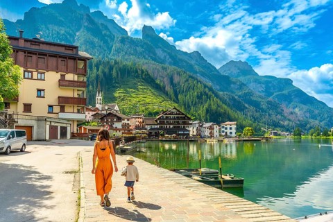 Tourists strolling along the lakefront of alleghe, a charming village nestled in the heart of the