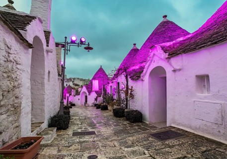 Trulli houses illuminated in purple light, Rione Monti, Alberobello, Apulia - Puglia, Italy, Europe
