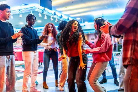 Cheerful multi ethnic friends dancing joyfully and enjoying their time together at the lively