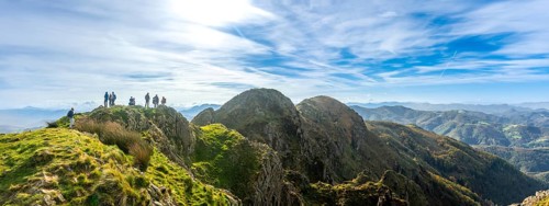 Group of hikers enjoying stunning views from the peak of aiako harria mountain in oiartzun,