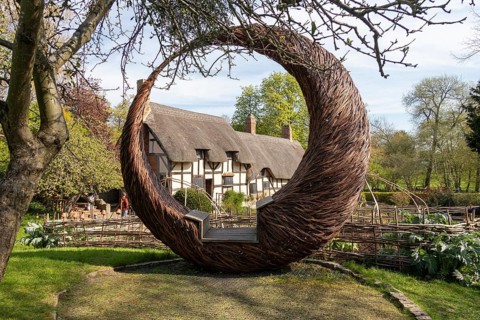Anne Hathaway's Cottage framed by a round wicker seat, Shottery, Stratford-upon-Avon, Warwickshire,