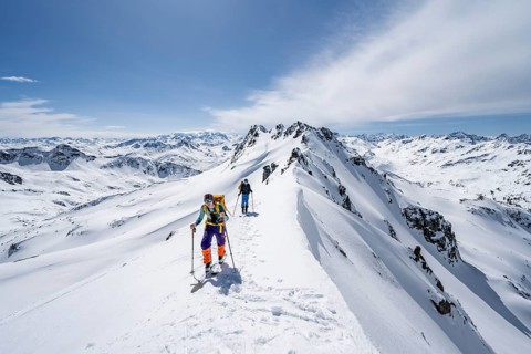 Two ski tourers on a mountain ridge, mountain landscape with snow, mountain panorama with peaks of