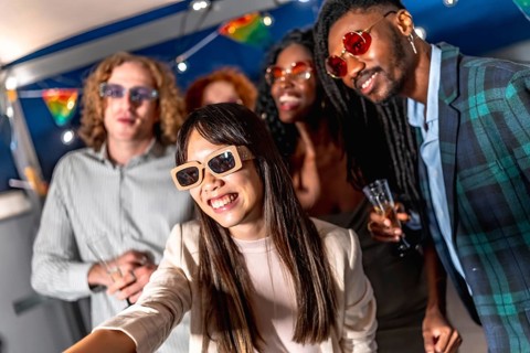 Chinese woman with elegant clothes and sunglasses taking selfie while enjoying night party with