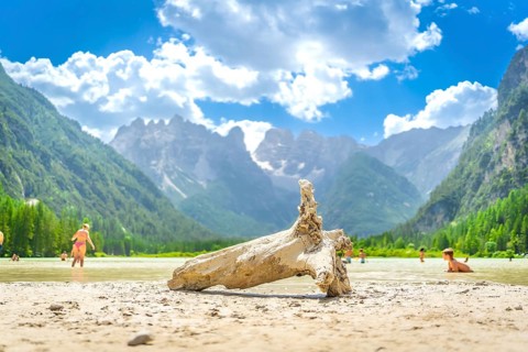 Tourists swimming in the stunning lago di landro, with the majestic dolomites rising in the
