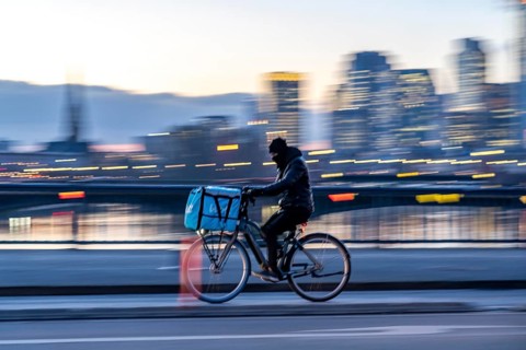 Skyline of the city centre of Frankfurt am Main, cyclist on the Flößerbrücke, Wolt delivery