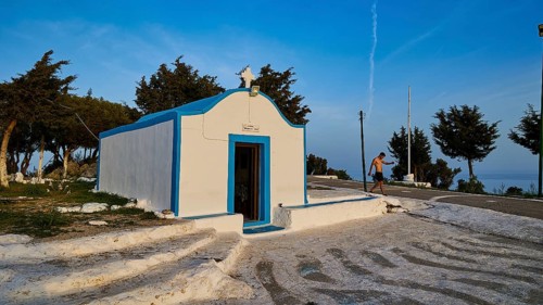 Profitis Ilias Chapel, White and blue chapel in Greece, surrounded by trees on a sunny day, Anthony
