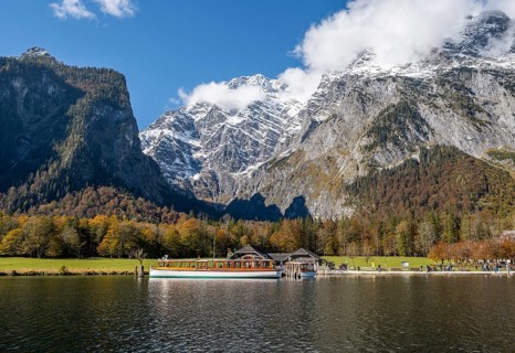 Königssee with Watzmann massif and St. Bartholomä jetty with tourist boat, autumnal mountain
