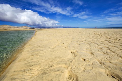 Extensive sandy beach Playa Risco del Paso, Playa de Sotavento with a clear blue sky and clouds,