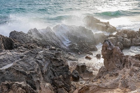 Sea water lashes over the eroded rocks on Salines beach, Ibiza, Balearic Islands, Mediterranean
