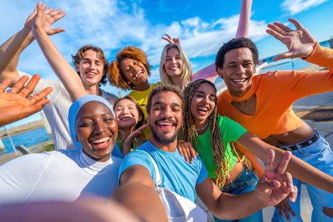 Large group of multi-ethnic happy young people taking a selfie in the city