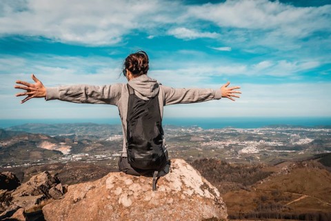 A young woman with open arms on top of Mount Adarra in Gipuzkoa. Basque Country