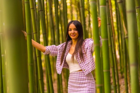 Young caucasian girl with a pink skirt in a bamboo forest. Enjoying the city on summer vacation in