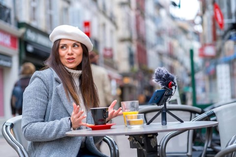 Woman with beret looking away and drinking coffee in a sidewalk cafeteria