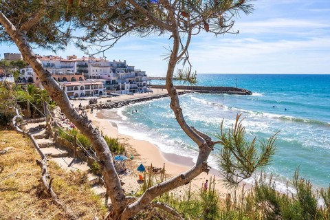 Scenic view of the mediterranean sea from cami de ronda, featuring white buildings, sandy beach,