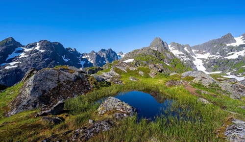 Small pond in moor landscape at Trollfjord Hytta, mountain landscape with rocky mountain peaks, at