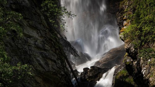 A rushing waterfall flows over rocks in a wooded setting, Roståa stream, near Sel, Gudbrandsdalen,