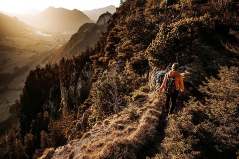 Hiker in the Allgäu at sunset in spring on the Zirmgrat near Pronten in the Allgäu