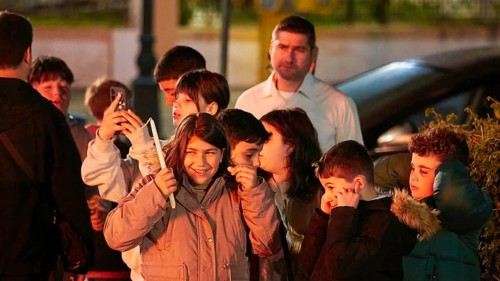 A group of children laughing and covering their ears, fireworks, Easter fire Psinthos, Holy