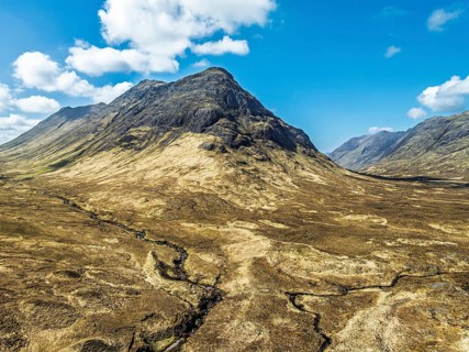 Buachaille Etive Beag and Three Sisters in Glencoe over Moors and Road A82 from a drone, Highlands,