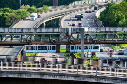 The Wuppertal suspension railway, train of the latest generation 15, crosses the A46 motorway,