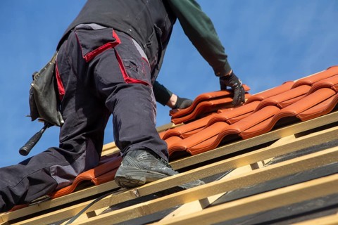 Roofer covering a tiled roof