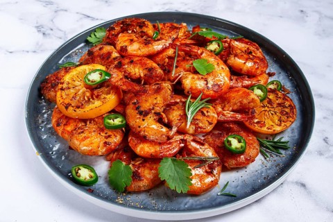 Grilled shrimp, unpeeled, headless, with spices, on a marble table, homemade, no people